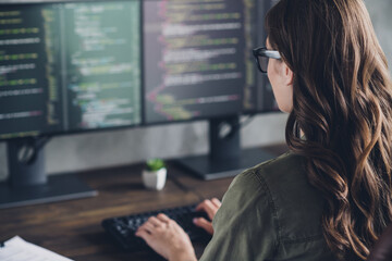 Cropped rear photo of smart web designer keyboard writing two monitor screens office building...