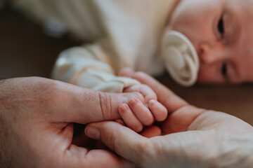 Close-up of parents cuddling their newborn baby.