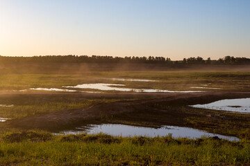 Sand dust over the freight road of an old sand pit