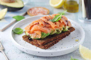 A rye bread sandwich with avocado and salmon