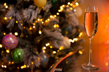 A glass of champagne on the background of a decorated Christmas tree
