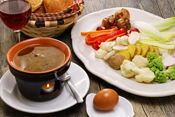 Bagna cauda(Italian Piedmont cuisine)  is a hot dip made from garlic and anchovies. 
The dish is served with raw or cooked vegetables typically used to dip into it.