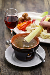 dipping celery. Bagna cauda(Italian Piedmont cuisine)  is a hot dip made from garlic and anchovies. The dish is served with raw or cooked vegetables typically used to dip into it.