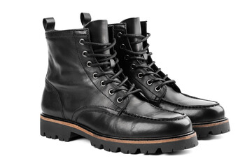 Pair of black leather boots, dress boots for men, men ankle high boots. Black brogue boots on a white background. Men fashion in leather boots. Man's legs in black jeans and brown leather boots.