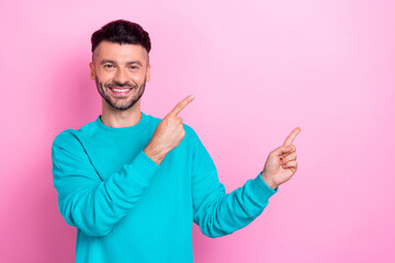 Photo of satisfied young optimistic toothy beaming smile guy recommend indicating fingers copyspace clinic isolated on pink color background