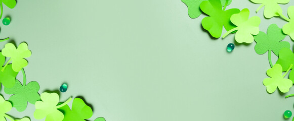 St. Patrick's Day banner. Paper clover leaves on colored background with copy space