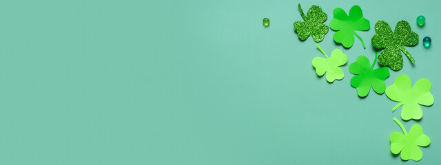 St. Patrick's Day minimalistic banner. Paper clover leaves on colored background with copy space