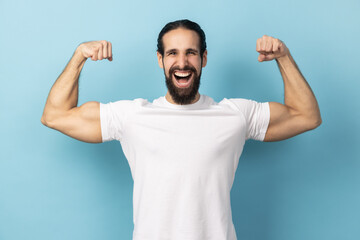 Fototapeta premium Man bodybuilder showing biceps raising strong arms, proud of muscular build, leadership.