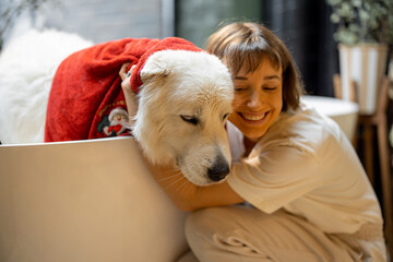 Young woman wipes her dog with a towel after taking a bath at home. Concept of animal care, spa...