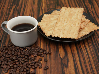 Tazza di caffe e chiacchiere sul piatto con chicchi di caffè sul tavolo