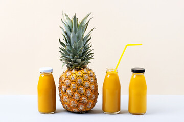 Pineapple and a fresh healthy smoothie in a glass bottles and a straw on a blue background. Healthy, detox and dietary nutrition concept.