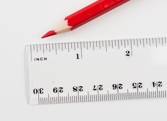 Transparent plastic ruler and red wooden pencil