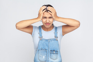 Depressed woman frowning, clasping sore head suffering intense headache having unbearable migraine.