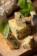Blue cheese slices close up, wooden rustic background