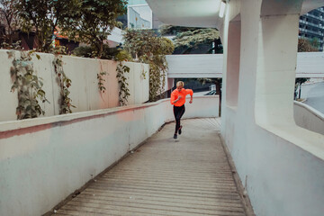 Women in sports clothes running in a modern urban environment et night time. The concept of a...