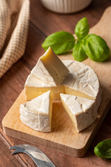 Brie, soft cheese slices on cutting board. Close up