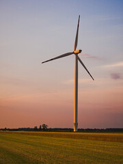 Turbina wiatrowa jako odnawialne źródło energii na tle zachodzącego słońca - obrazy, fototapety, plakaty