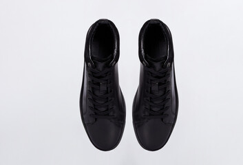 Above view on black fashionable business men's leather slip-on shoes sneakers for male isolated on white background. Sport casual basic shoes. Placed together. Flat lay