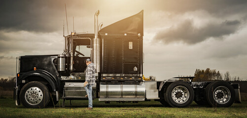 Obraz na płótnie Canvas American Semi Truck Driver Next to His Tractor Truck
