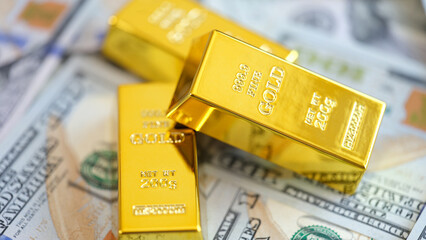Close-up yellow gold ingots lie on money