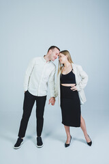 Beautiful young couple in love hugging on a white background. A stylish couple embraces and enjoys feelings. Men and women in stylish casual clothes