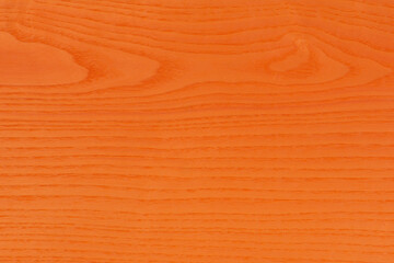 Orange wood texture. The large textured wood of the ash tree is painted orange. Orange ash.