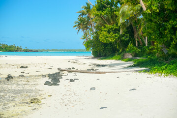 Mother and children on coral sandbank and kayak on foreshore