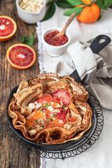 French Crepe with bloody oranges with  syrup and almonds. Delicious breakfast with pancakes