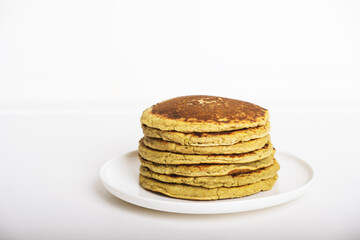 Delicious freshly cooked avocado pancakes stacked on white plate. Copy space for text. Healthy gluten free food.