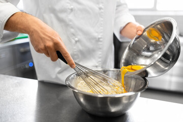 cooking food, baking and people concept - close up of male chef cook whipping dough or batter by whisk in bowl at restaurant or bakery kitchen - obrazy, fototapety, plakaty
