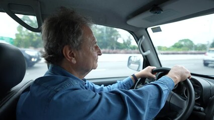 Person driving car in motion on road. One senior mature male caucasian person in 70s drives vehicle transportation on highway