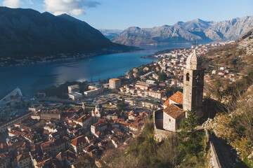 Naklejka na ściany i meble Church of Our Lady of Remedy in Kotor, Montenegro, beautiful top panoramic view of Kotor city old medieval town seen from San Giovanni St. John Fortress, with Adriatic sea, bay of Kotor and mountains
