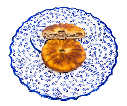 Tatar cuisine - one and half Peremech (fried pastry stuffed with minced meat) on ornamental plate isolated on white background