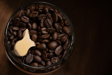 Coffee Beans display in dark background in dark wooden base with wooden spoon in glass mason jar