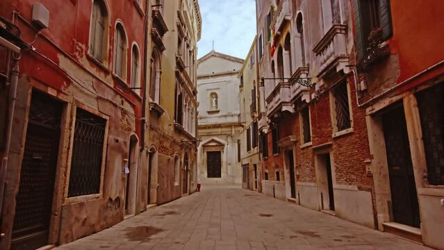 Bricked sidewalk between old shabby terracotta buildings