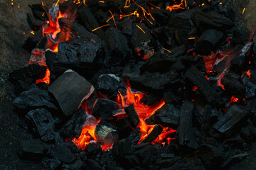 Coals with sparks in a huge old metal grill