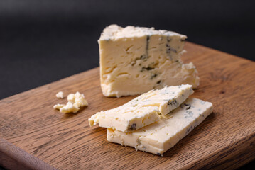 Delicious fresh cheese with blue mold dorblu on a wooden cutting board