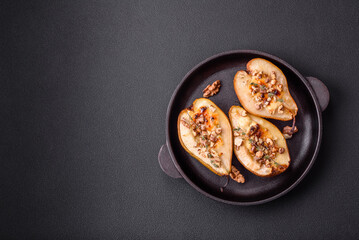 Delicious baked pear with dorblu cheese, walnut and honey on a textured concrete background