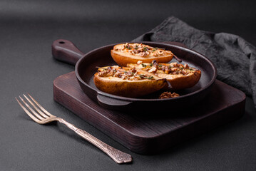 Delicious baked pear with dorblu cheese, walnut and honey on a textured concrete background