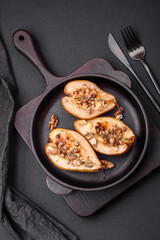 Delicious baked pear with dorblu cheese, walnut and honey on a textured concrete background