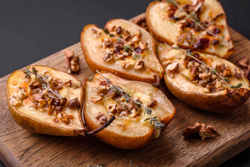 Delicious baked pear with dorblu cheese, walnut and honey on a textured concrete background