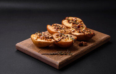 Delicious baked pear with dorblu cheese, walnut and honey on a textured concrete background