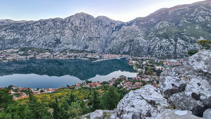 Panoramic view from mountain summit of Sveti Ilija on Kotor bay during sunrise, Adriatic Mediterranean Sea, Montenegro, Balkans, Europe. Fjord winding along steep cliffs. Hiking trail in Dinaric Alps