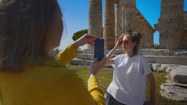 Teenage girl is photographed in front of an ancient temple.