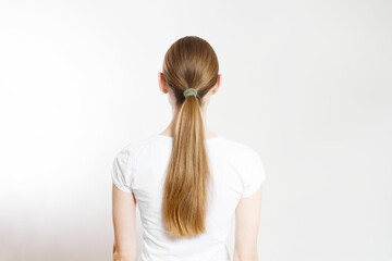 Closeup woman ponytail back view isolated on white background. Hair Natural blonde straight long Hairstyle. Easy quick simple making styling. Hair-extensions for beautiful pony tail. Copy space