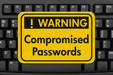 Comprised Passwords message on a sign on a computer keyboard