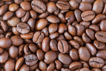 Roasted coffee beans background, top view macro, Coffea.