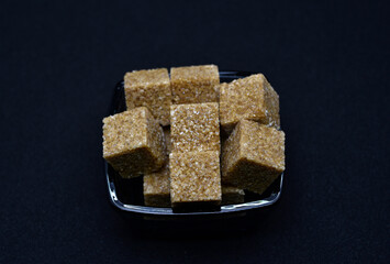 Pieces of cane sugar in a bowl. Refined sugar. Sugar in chunks in a cup.