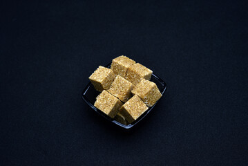 Pieces of cane sugar in a bowl. Refined sugar. Sugar in chunks in a cup.