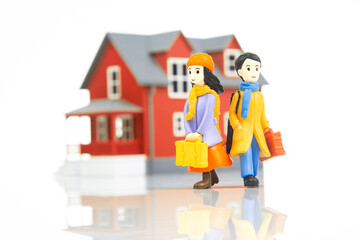 miniature people. romantic couple of young people near the house model on a white background. friendship and great relationship